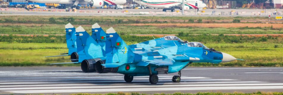 a blue fighter jet sitting on top of an airport runway
